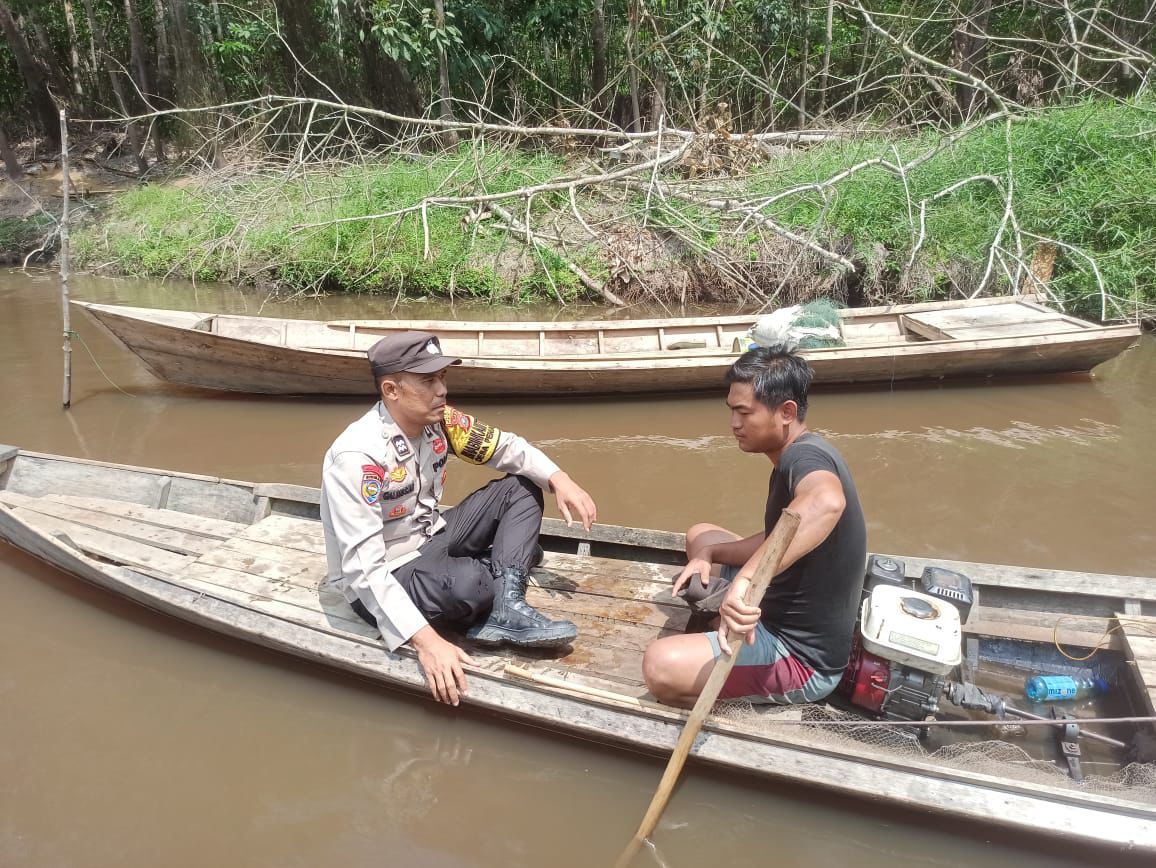 Di Atas Perahu, Polisi Jangkau Warga Desa Penarikan Kecamatan Langgam Kawal Pilkada Damai