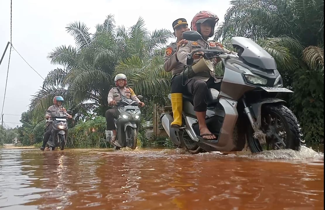 Bawa Pesan Pemilu Damai, Kapolsek Kuala Cenaku Terobos Banjir Sambangi Warga