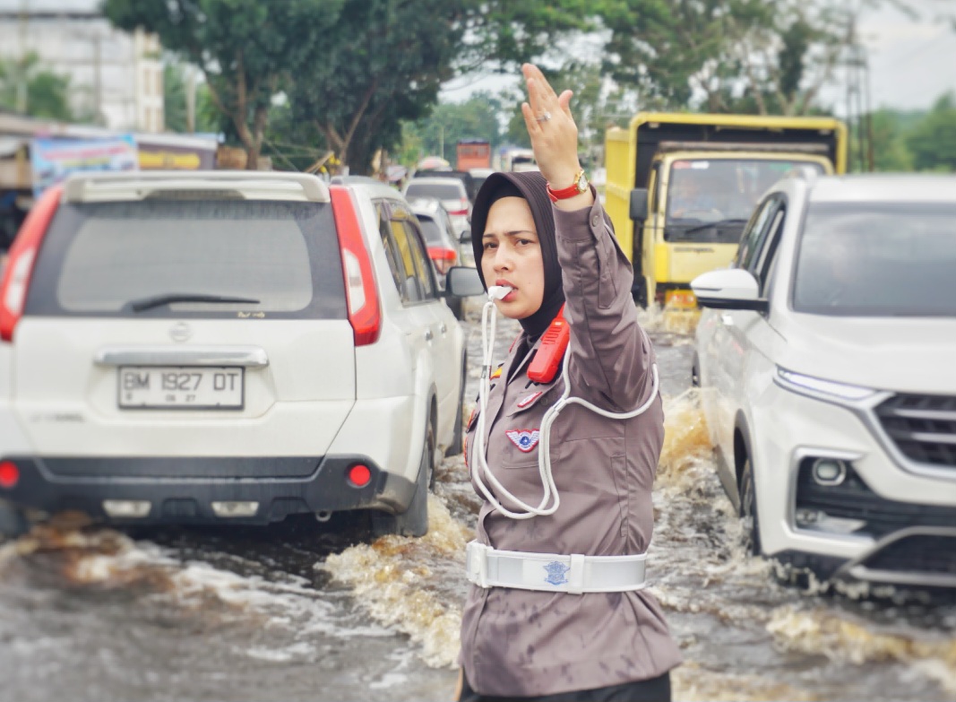 Aksi Perwira Polwan Cantik Tutupi Lubang yang Digenangi Banjir di Rohil