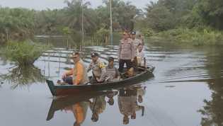 Banjir Meluas, Polsek Rengat Barat Gunakan Sampan saat Cooling System Pemilu Damai