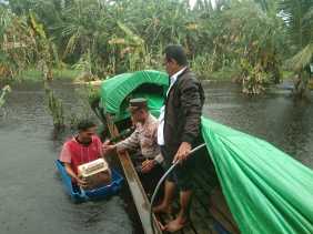 Gunakan Sampan Kayu, Kapolsek Gaung di Inhil Riau Berikan Bantuan Warga Terdampak Banjir dan Sosialisasi Pemilu Damai