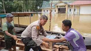 Kapolsek Siak Hulu Naik Perahu Bantu Korban Banjir Sambil Sosialisasi Pemilu